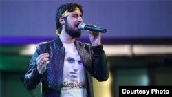 A photo shows Hamed Zaman, a well-known Iranian singer, supporting the shrine defenders during a recent performance. Source: Tasnim News