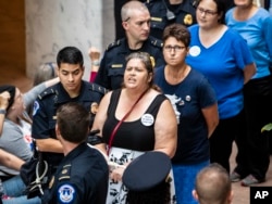 Protesters opposed to President Donald Trump's Supreme Court nominee, Brett Kavanaugh, are arrested outside the office of Judiciary Committee Chairman Chuck Grassley, R-Iowa, in the Hart Senate Office Building on Capitol Hill in Washington, Sept. 20, 2018.