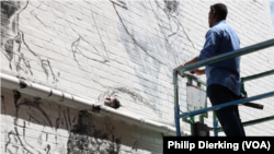 D.C. artist Aniekan Udofia works on his new mural for MuralsDC