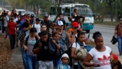 FILE - In this April 10, 2019 file photo, migrants walk at dawn as part of a new caravan of several hundred people sets off in hopes of reaching the distant United States, in San Pedro Sula, Honduras. (AP Photo/Delmer Martinez, File)