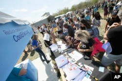 Attendees create climate science posters at the Cool Effect Expo tent during the March for Science on Saturday, April 14, 2018, in Washington, D.C.