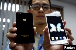 រូបភាព​ឯកសារ៖ បុរស​ម្នាក់​បង្ហាញ​ទូរស័ព្ទ​ស្មាតហ្វូន​វៀតណាម​ម៉ាក Bphones នៅ​ក្នុង​រោងចក្រ BKAV ក្នុង​ក្រុង​ហាណូយ ប្រទេស​វៀតណាម កាលពី​ថ្ងៃទី៥ ខែកក្កដា ឆ្នាំ២០១៧។