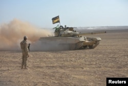 Dust clouds from travelling Iraqi army vehicles are seen during an operation to attack Islamic State militants in Mosul, Iraq, Oct. 21, 2016.
