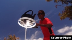 A boy tends a kettle boiling one on of the parabolic cookers (Photo: Sunfire)