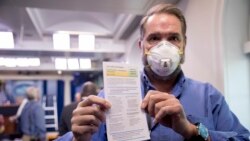 Novinar Brajan Fas pokazuje informacije o svom testu na Kovid-19 nakon što se testirao u ambulanti Bele kuće pre konferencije za novinare predsednika Trampa, 9. aprila 2020.