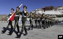 In this photo taken October 1, 2011, Chinese paramilitary police march during a flag raising ceremony near Potala Palace in Lhasa in northwestern China's Tibet province.