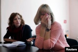 FILE - Biruta Kadakovska (R) talks with migration researcher and social anthropologist Dace Dzenovska during an interview in Malnava, Latvia, Feb. 29, 2012. Latvia's census data of year 2011 shows that in the eastern regions of country, population decreased up to 30 percent.