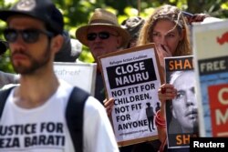 FILE - Protesters react as they hold placards and listen to speakers during a rally in support of refugees in central Sydney, Australia, Oct. 19, 2015.