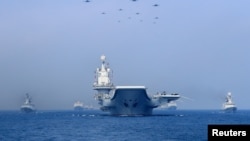 FILE PHOTO - Warships and fighter jets of the Chinese People's Liberation Army (PLA) Navy take part in a military display in the South China Sea April 12, 2018.