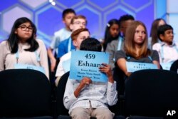 Eshaan Sanka, 9, of Helotes, Texas, reads the back of his name tag in the third round of the Scripps National Spelling Bee, Wednesday, May 29, 2019, in Oxon Hill, Md.