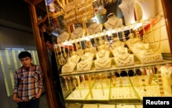 Mahamet, a 17-year-old Syrian boy from Azaz, waits for customers in front of the jewelry shop where he works as a translator in Kilis on the Turkish-Syrian border, March 18, 2014.