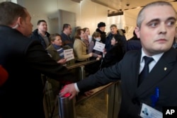 Hard-currency mortgage holders, show banners reading "Hard-Currency Mortgage is Plague", as they gather during a protest in a bank office in Moscow, Russia, Jan. 28, 2016.