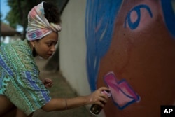 Graffiti artist Maiara Viana Rodrigues paints a mural at her home neighborhood in Rio de Janeiro, Brazil, March 7, 2017. "We use graffiti to end violence against women," says the 25-year-old designer and visual artist.