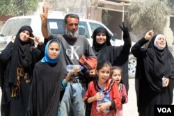 A few families, like this one, are so excited to see Iraqi forces they forget their sorrow and shout, "Thank you!" and "God bring you to victory!" in Mosul, Iraq, June 4, 2017. (H. Murdock/VOA)