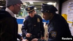 Polisi New York melakukan pemeriksaan tas yang dibawa penumpang di stasiun kereta bawah tanah Times Square (16/4).