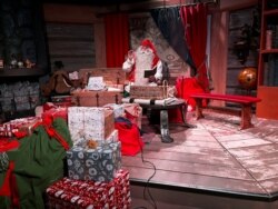 Seorang pria berpakaian Sinterklas berfoto di Desa Sinterklas di Lingkaran Arktik dekat Rovaniemi, Finlandia, 3 Desember 2021. (REUTERS/Attila Cser)