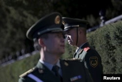 FILE - Paramilitary police officers stand guard for a welcoming ceremony for Germany's Chancellor Angela Merkel outside the Great Hall of the People in Beijing, China. A new report from Amnesty International alleges Chinese police widely use torture.