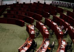 Empty seats of pro-democracy legislators, top, are seen at Legislative Chamber in Hong Kong, Thursday day, Nov. 12, 2020.