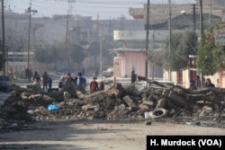 Streets around military bases near the front lines in Mosul are baracaded with piles of dirt and old vehicles to prevent car bombs from approaching in Mosul, Iraq, Jan. 11, 2017.