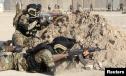 Members of Iraqi Popular Mobilization Forces demonstrate their skills during a military exercise at a graduation ceremony in Basra, Iraq Jan. 31, 2019.