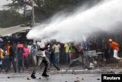 A supporter of Kenyan opposition leader Raila Odinga is sprayed with water by police in Nairobi, Nov. 17, 2017.