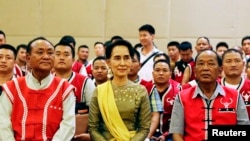 FILE - Myanmar's Foreign Minister Aung San Suu Kyi sits with members of the United Wa State Army (UWSA) following a meeting of armed ethnic groups in Naypyitaw, Myanmar, July 29, 2016.