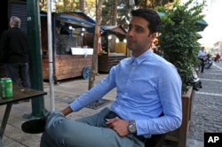 Ashkan Ashtari, a 30-year-old electronics importer, speaks during an interview with The Associated Press at a street food market, in downtown Tehran, Iran, Oct. 8, 2017.