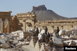 Syrian army soldiers stand on the ruins of the Temple of Bel in the historic city of Palmyra, in Homs Governorate, Syria, April 1, 2016.