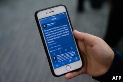 The @HKsisters6 Twitter account feed of Saudi sisters Rawan (not seen), 18, and Reem, 20, (both using adopted aliases) is held by Reem during an interview with AFP in Hong Kong, Feb. 22, 2019.