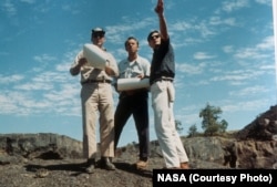 Astronauts Edgar Mitchell and Alan Shepard being guided by a NASA geologist at Craters of the Moon before their lunar mission in 1969.