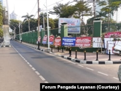 Karangan bunga di dekat pintu masuk bagian belakang kompleks DPR di Senayan dari berbagai organisasi perempuan sebagai bentuk keprihatinan dan mendesak DPR agar segera mengesahkan Rancangan Undang-Undang Penghapusan Kekerasan Seksual (RUU PKS), Jakarta. (Foto: Forum Pengada Layanan)