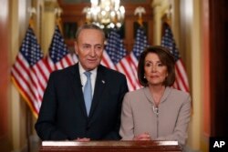 FILE - House Speaker Nancy Pelosi, right, and Senate Minority Leader Chuck Schumer pose for photographers after speaking on Capitol Hill in response President Donald Trump's prime-time address on border security, in Washington, Jan. 8, 2019.