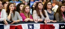 FILE - Young women listen to first lady Michelle Obama speak during a campaign rally for Democratic presidential candidate Hillary Clinton in Manchester, N.H., Oct. 13, 2016.