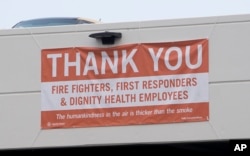 In this photo taken Aug. 2, 2018, a thank-you banner for firefighters, first responders and hospital workers hangs outside Mercy Medical Center in Redding, Calif. Dozens of staff members, including doctors, nurses and others at the medical center, are keeping the hospital running despite losing their homes to the flames.