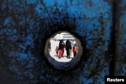 Refugee schoolchildren walk with their mothers on the first day of the new school year at one of the UNRWA schools at a Palestinian refugee camp al Wehdat, in Amman, Jordan.