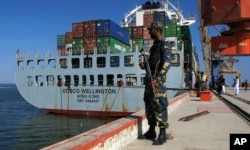 A Pakistan Navy soldier stands guard while a loaded Chinese ship is readied for departure at Gwadar port, Nov. 13, 2016.