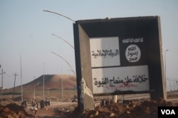 Signs proclaiming IS rule still stand in areas recaptured by Iraqi and coalition forces in recent days, often marked with graffiti like this one, proclaiming that Shi'ite Muslims, considered apostates by IS militants, remain in Mosul, Iraq, Jan. 23, 2017.