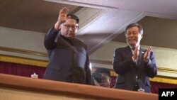 This picture captured from video footage by Korea Pool reporters shows North Korean leader Kim Jong Un (L) and South Korea's Culture, Sports and Tourism Minister Do Jong-whan (R) during a rare concert by South Korean musicians.