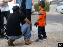 Jose and his 3-year-old son Jose Jr., from Honduras, share a moment after they were reunited July 10, 2018, in Phoenix.