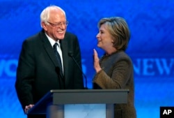 Hillary Clinton, right, speaks to Bernie Sanders during a break at the Democratic presidential primary debate, at Saint Anselm College in Manchester, N.H., Dec. 19, 2015.