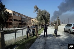 Iraqi federal policemen celebrate the retaking of Mosul airport, outside western Mosul, Iraq, Feb. 24. 2017.