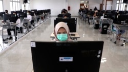A student in Indonesia takes a computer-based college admissions test.
