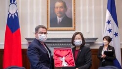 FILE - In this photo released by the Taiwan Presidential Office, outgoing Honduran President Juan Orlando Hernandez, left, exchanges gifts with Taiwanese President Tsai Ing-wen during a meeting in Taipei, Taiwan, Nov. 13, 2021.
