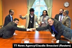 At left, Abdelqader al-Murtada and Saelem Mohammed Noman Al-Mughalles, representatives of the Ansar Allah delegation and at right, Askar Zaeil and Hadi al-Hayi representing the delegation of the Government of Yemen react at the negotiating table together with representatives from the office of the U.N. Special Envoy for Yemen and the International Red Cross Committee (ICRC) when lists of prisoners are exchanged, a first step to implement the agreement to release all prisoners by the two parties, during the ongoing peace talks on Yemen held at Johannesberg Castle, in Rimbo, near Stockholm, Sweden, Dec. 11, 2018.