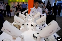 FILE - a man looks at security cameras at the Global Sources trade fair, a trade fair where Chinese manufacturers meet western buyers in Hong Kong.