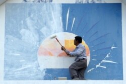 រូបឯកសារ៖ អ្នកគាំទ្រគណបក្សសង្គ្រោះជាតិម្នាក់លាបថ្នាំពី​លើ​ស្លាកសញ្ញាគណបក្សនេះនៅឯទីស្នាក់ការគណបក្សក្នុងរាជធានីភ្នំពេញ ថ្ងៃទី១៨ ខែវិច្ឆិកា ឆ្នាំ២០១៧។