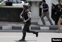 An Indonesian policeman runs near the site of a blast in Jakarta, Jan. 14, 2016.