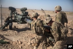 FILE - U.S. soldiers ready a howitzer to be towed into position at Bost Airfield in Afghanistan's Helmand Province in this June 10, 2017 photo provided by Operation Resolute Support.