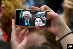 FILE - A supporter of Democratic presidential candidate Sen. Bernie Sanders, I-Vt., takes a selfie with the candidate during a campaign rally in Minneapolis, Minnesota, Feb. 29, 2016.