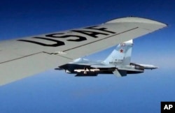 A U.S. RC-135U flying in international airspace over the Baltic Sea is intercepted by a Russian SU-27 Flanker on June 19, 2017.